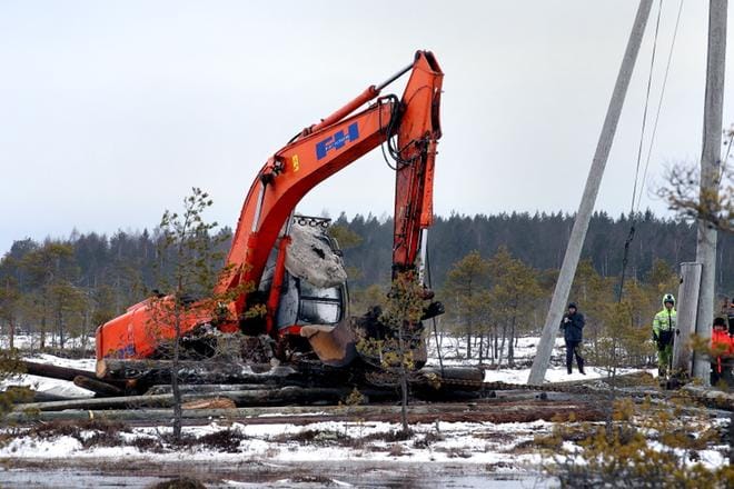 Kovan onnen kaivinkone on ryöminyt vinssin voimalla ylös suohaudastaan. Puut auttavat kulkua. KUVAT: JOUKO HÄNNINEN