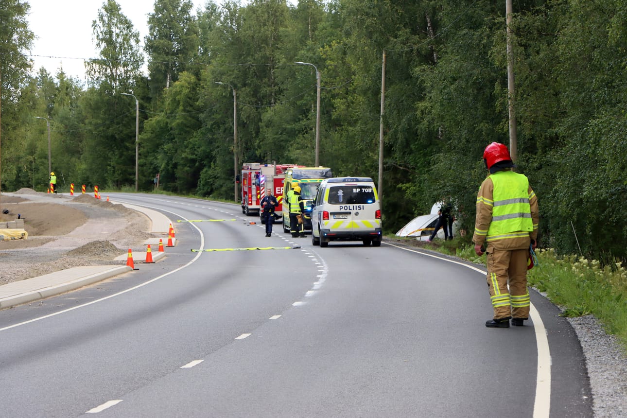 Henkilöauto oli keula pystyssä Jurvantien ojassa tiistai-illalla. Pelastuslaitoksen miehet ohjasivat liikennettä tiellä.