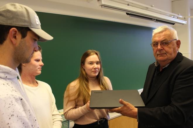 Suomenkielisen lukion abiturientit, kristiinalaiset Adam Ziazikov ja Jesse Hietikko sekä karijokelainen Aino Hautaniemi vastaanottivat koulunsa puolesta yhden kannettavan tietokoneen laitteet hankkineelta peruslaiselta Allan Nyholmilta. KUVA: LOTTA KALLIO