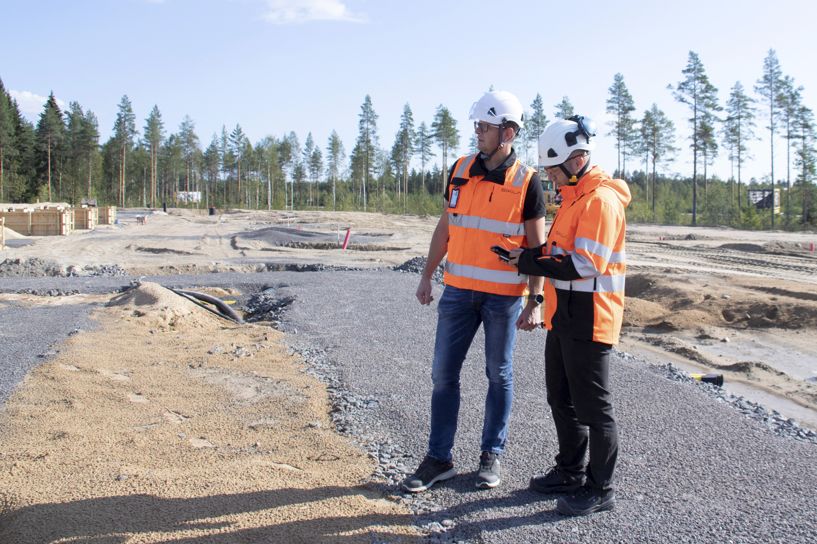 Tommi Myllyneva ja Lasse Kaikkonen kertovat toimiston tulevalla perustuspaikalla, kuinka rakennukset sijoittuvat Nelostien vierellä olevalle tontille.