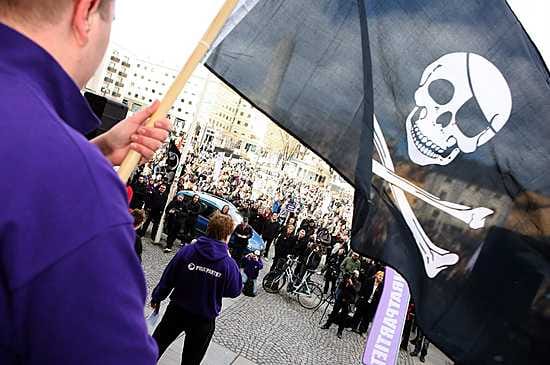 Mielenosoittaja heilutti lippua Pirate Bay-mielenosoituksessa lauantaina.