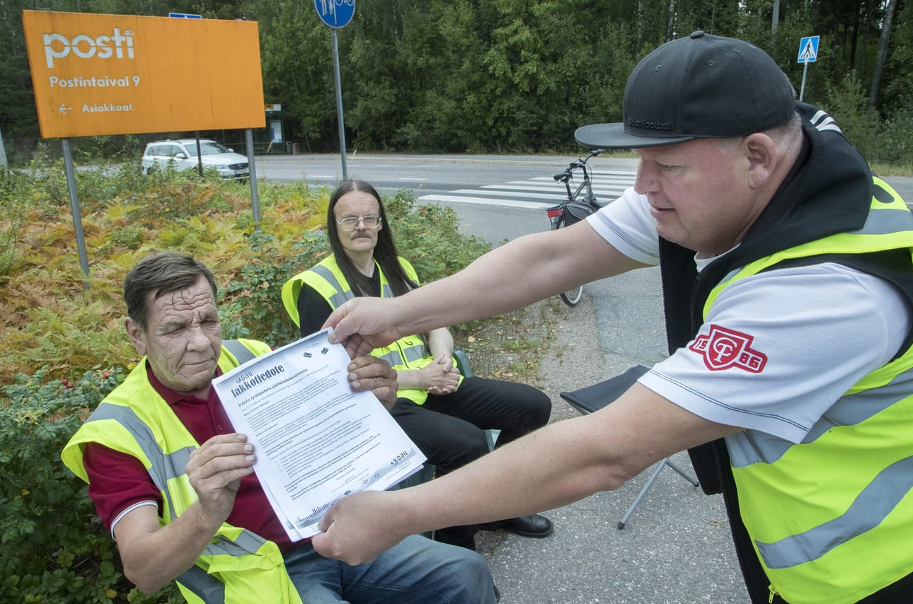 Pääluottamusmies Pertti Touhonen (vas.) ja luottamusmies Ilkka Silo istuivat maanantaina lakossa Postin jakelukeskuksen edessä Helsingissä. Jari Havunen piti lakkotiedotetta.