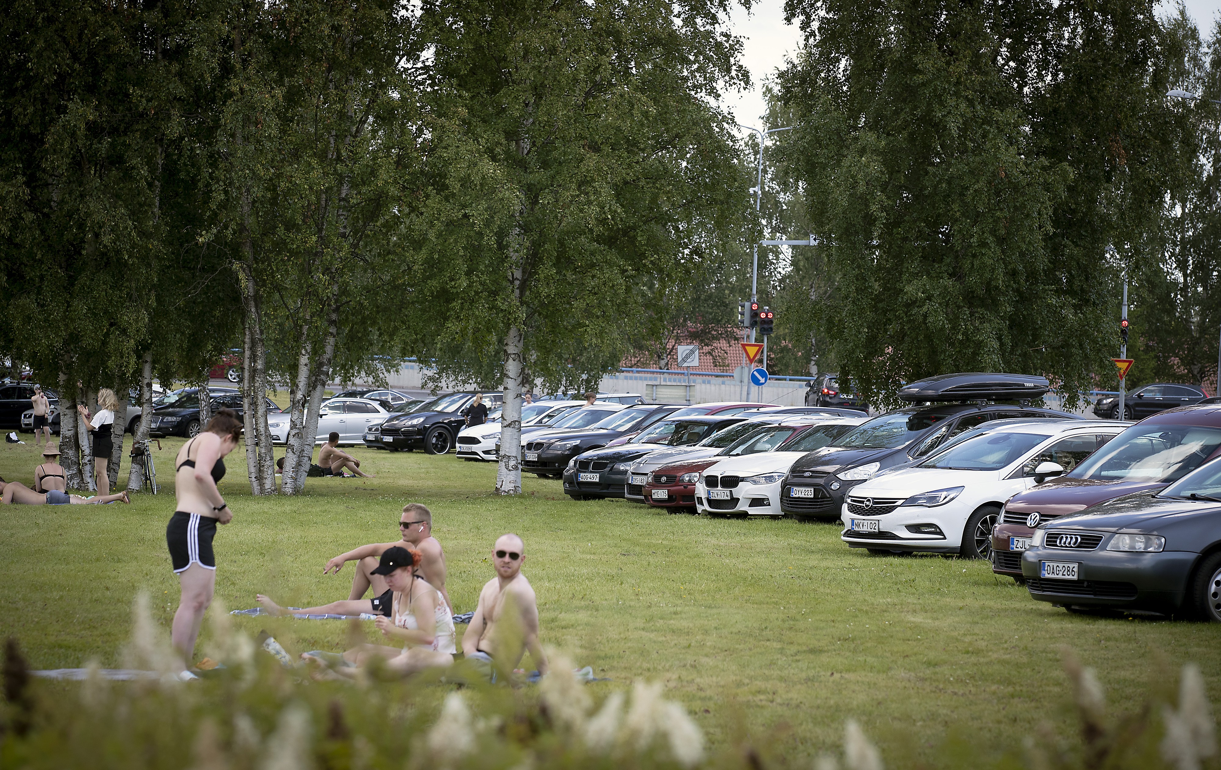 Värtön uimarannan viereistä nurmialuetta reunustavat helteistä nauttivien autot. Yrittäjiä vähäinen parkkitila häiritsee, rannalla kävijöitä ei niinkään.