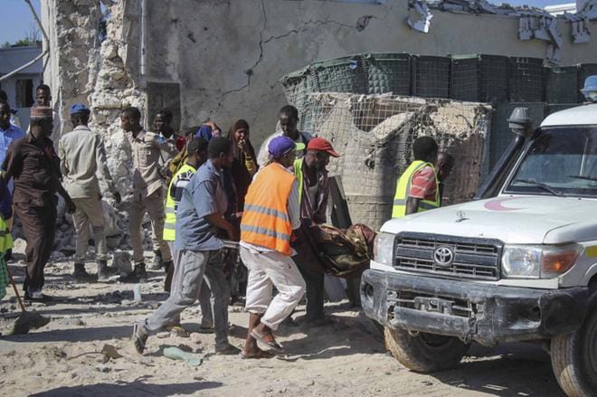 Pommi-iskun uhria kannetaan pois räjähdyspaikalta Mogadishussa. KUVA: EPA/SAID YUSUF WARSAME