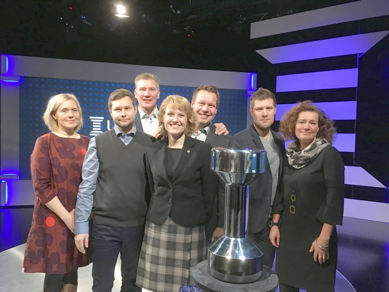 Suomen liikkuvin kunta -kilpailun finalistit Ylen suorassa tv-lähetyksessä. Vasemmalta Pudasjärven kaupunginvaltuuston puheenjohtaja Mari Kälkäjä ja liikunta-ja hyvinvointipalvelujen koordinaattori Ismo Miettinen, Asikkalasta Aurinkovuoren koulun rehtori Petri Haapanen, kunnanjohtaja Rinna Ikola-Norrbacka ja hyvinvointijohtaja Matti Kettunen sekä Pieksämäeltä liikuntapalvelupäällikkö Antti Nousiainen ja kulttuuri-ja vapaa-aikajohtaja Päivi Majoinen.