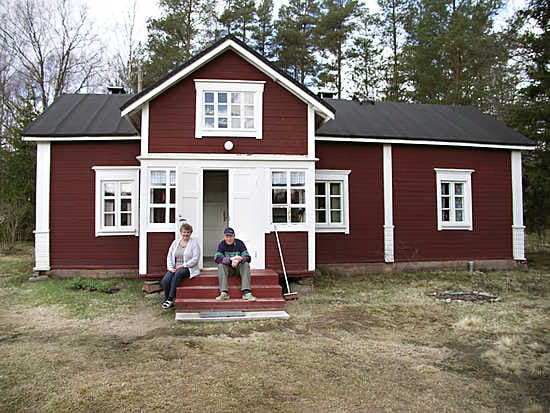 Vihantilaisessa Autiomäen pihapiirissä istuskelevat kunnostetun päärakennuksen portailla Sinikka ja Veli Karihtala.