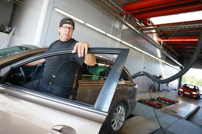 Suomen Laatukatsastuksella Taneli Kuula katsastaa asiakkaan autoa. Hellekelit tuovat fyysiseen työhön omat lisämausteensa. KUVA: SAMPPA TOIVONEN