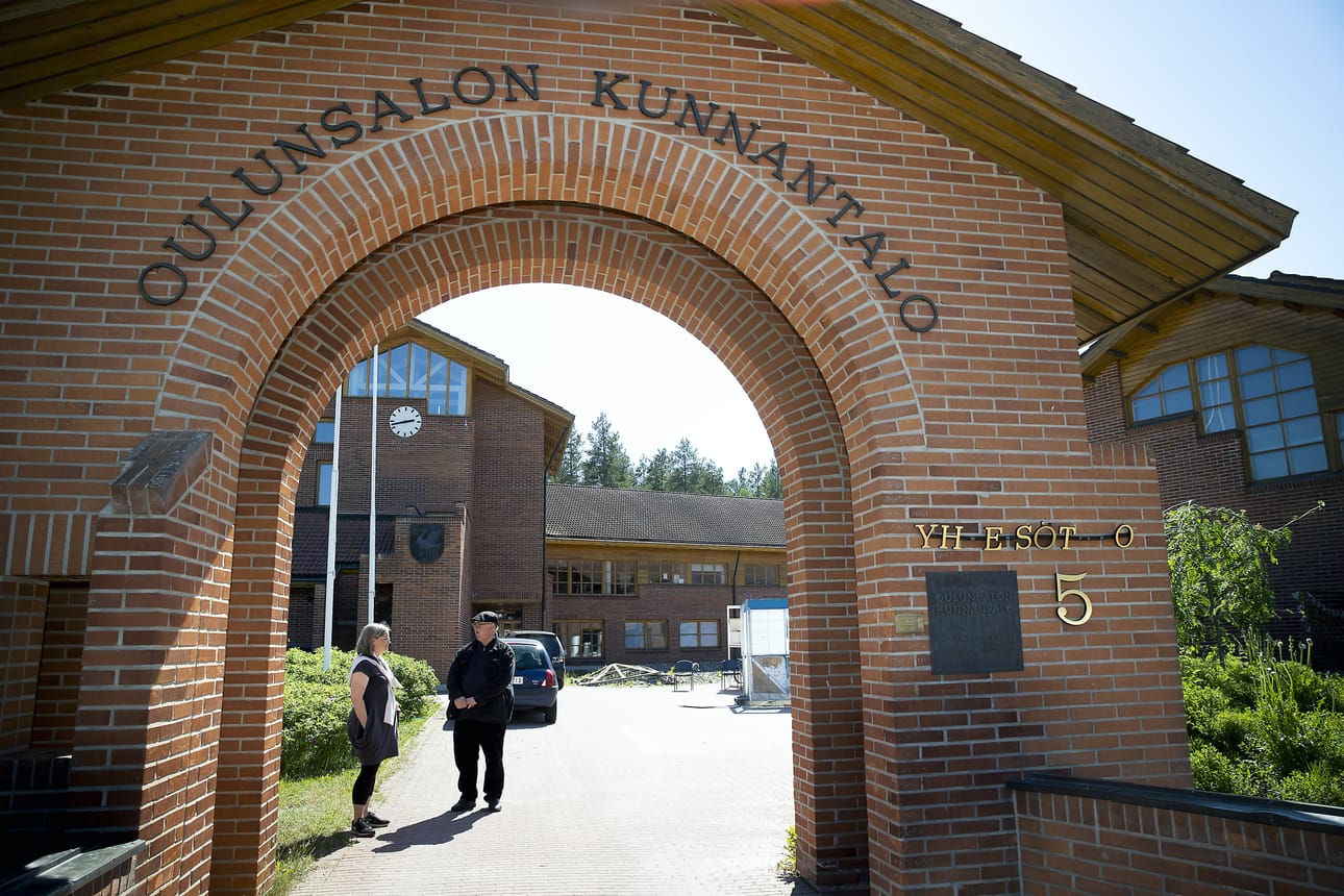 Oulunsalon entisen kunnantalon sisäpihalle johtava portti on talon vahva maamerkki. Arkkitehti Kari Niskasaari kertoo kaavoitusarkkitehti Pia Krogiukselle mitä istutuksia hän aikoinaan pihalle määräsi.