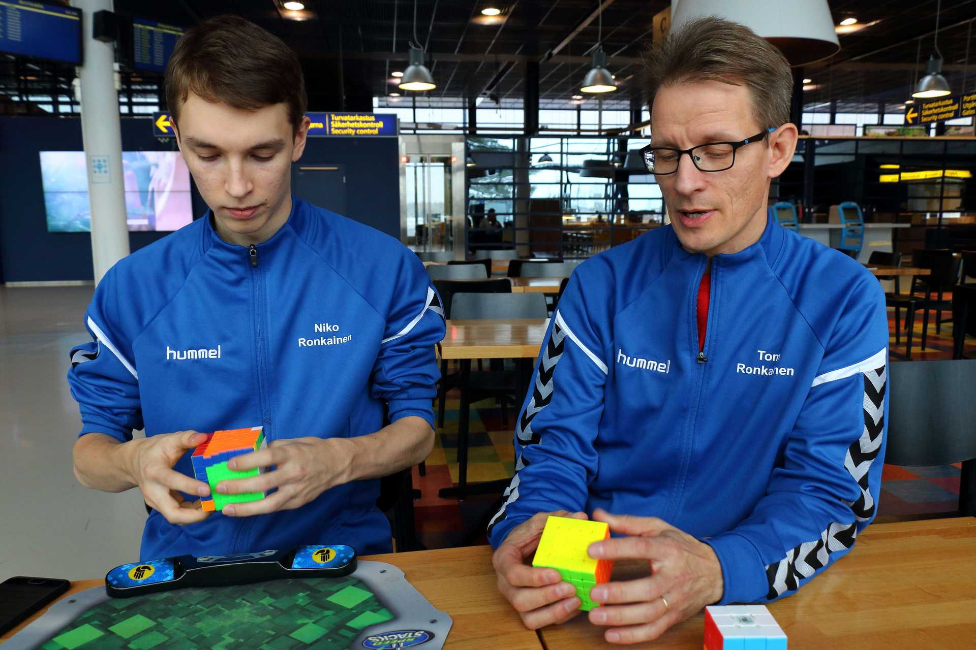 Niko Ronkainen ratkoo kuutioita ja raahelaislähtöinen isä Tomi Ronkainen tuomaroi. He vierailivat viikonloppuna Oulu Open -kisoissa.