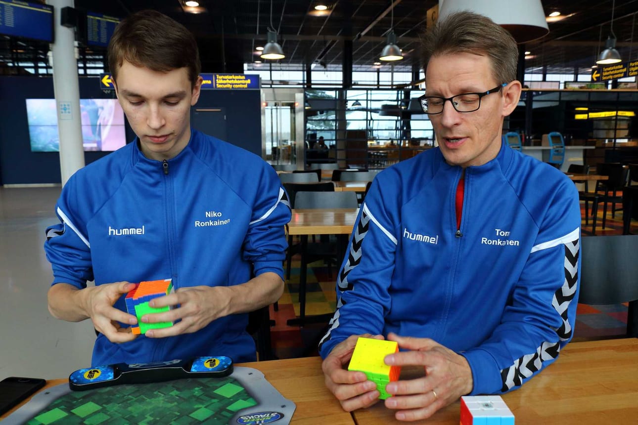 Niko Ronkainen ratkoo kuutioita ja raahelaislähtöinen isä Tomi Ronkainen tuomaroi. He vierailivat viikonloppuna Oulu Open -kisoissa.
