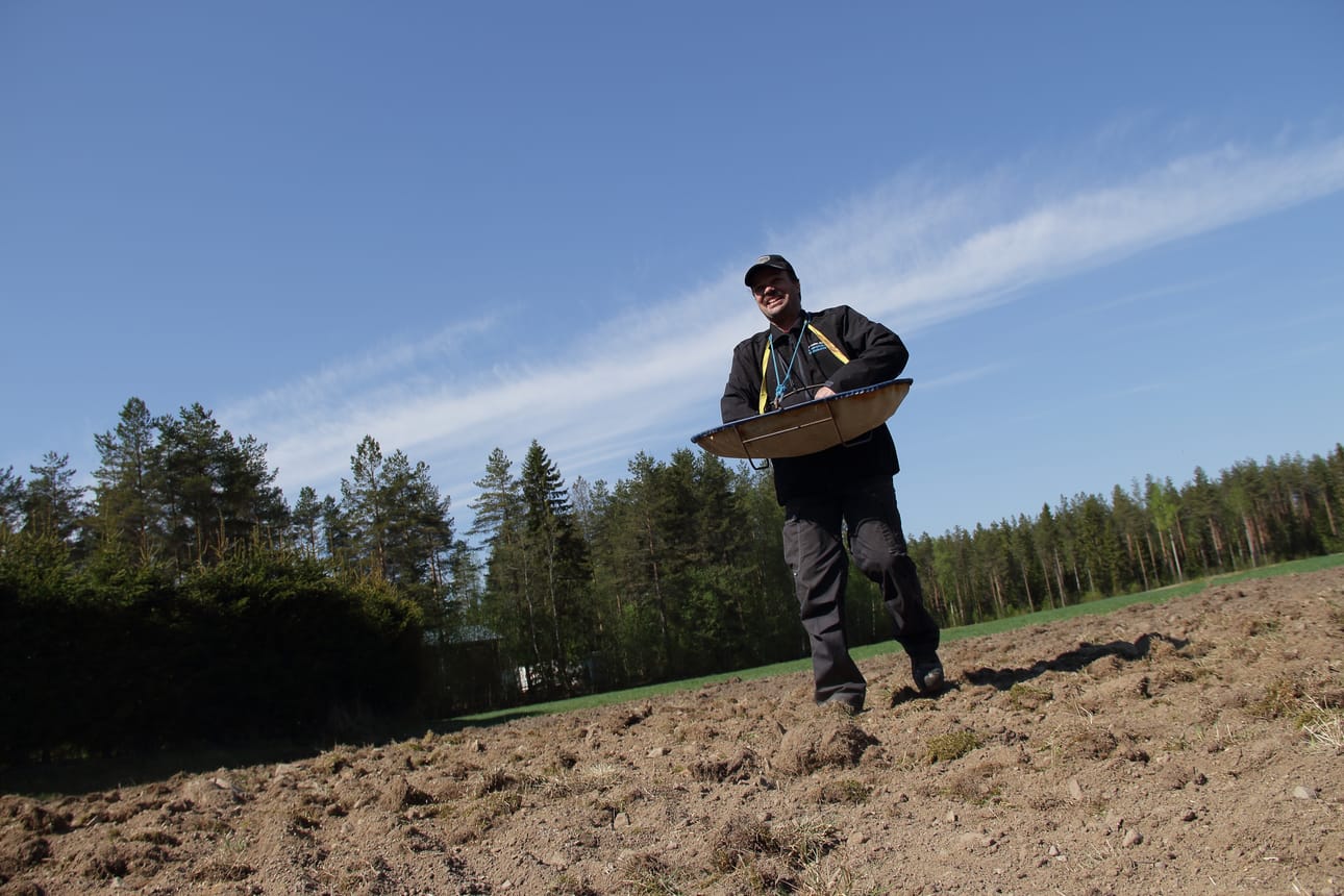 Arvolan tilan isäntä Janne Heikkilä kylvää käsin peltoaan toukosiunauksessa Haapavedellä.